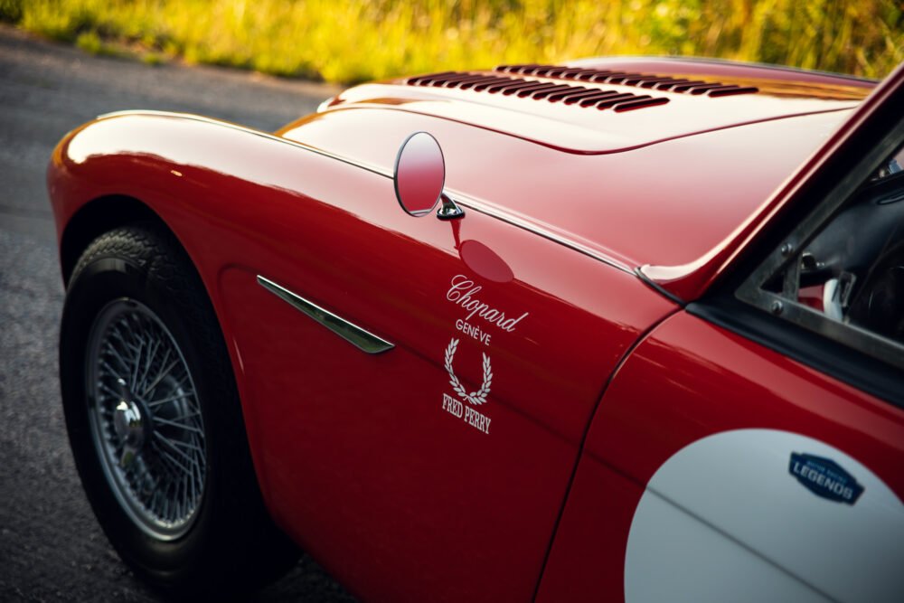 Red vintage sports car with elegant logos and details.