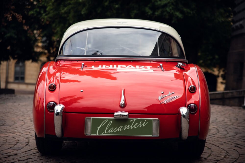 Red vintage car with Unipart logo and stylish tail lights.