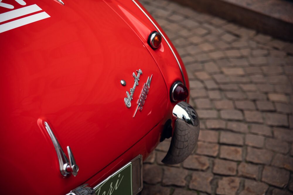 Close-up of vintage red Ferrari rear emblem and lights.