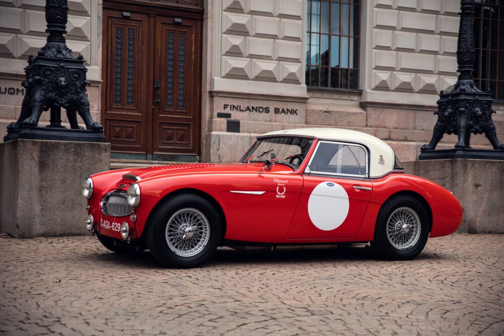 Vintage red sports car outside Finland's Bank building.