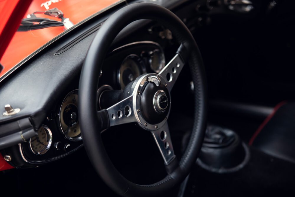 Vintage car's steering wheel and dashboard details.