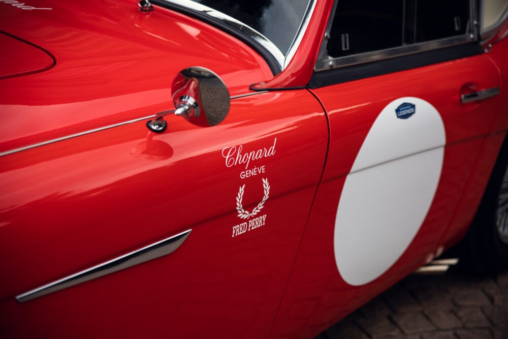 Red vintage sports car with sponsor logos.