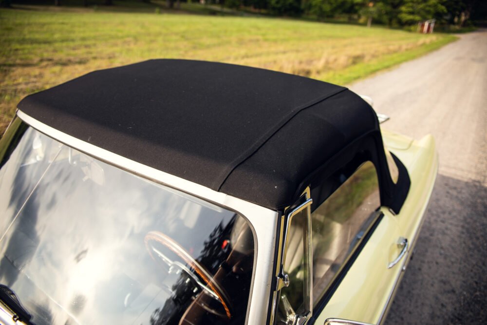 Vintage convertible car on country road.