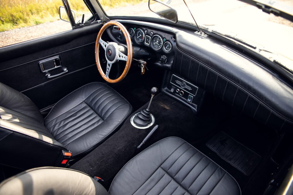 Classic car interior with wooden steering wheel.