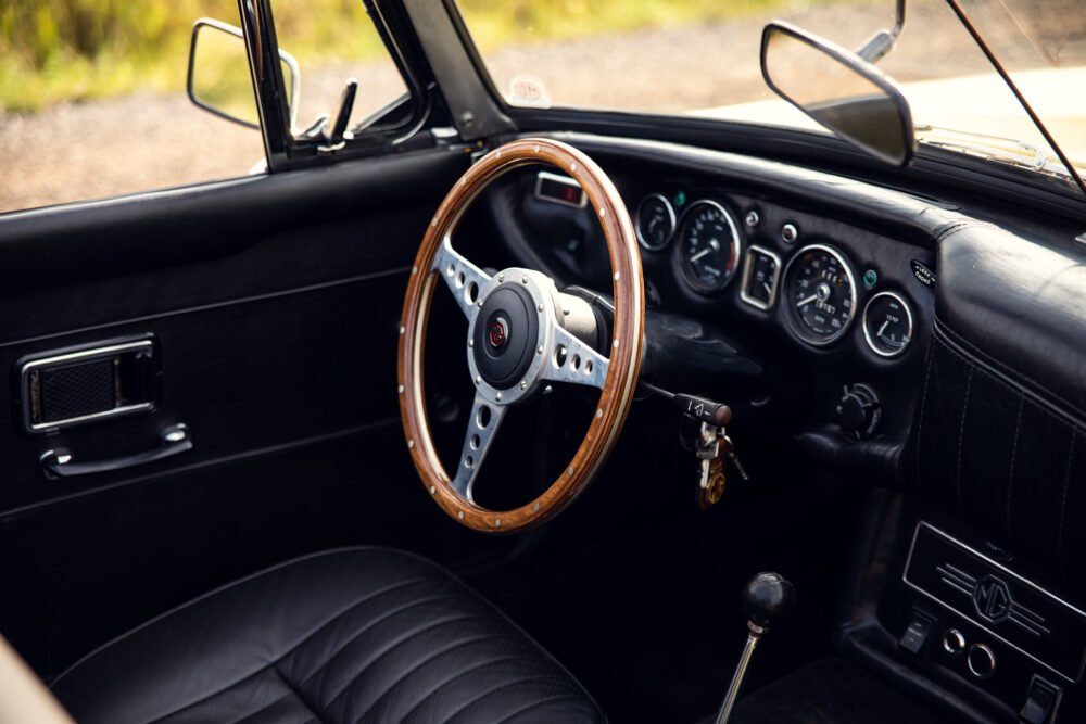 Classic car interior with wooden steering wheel.