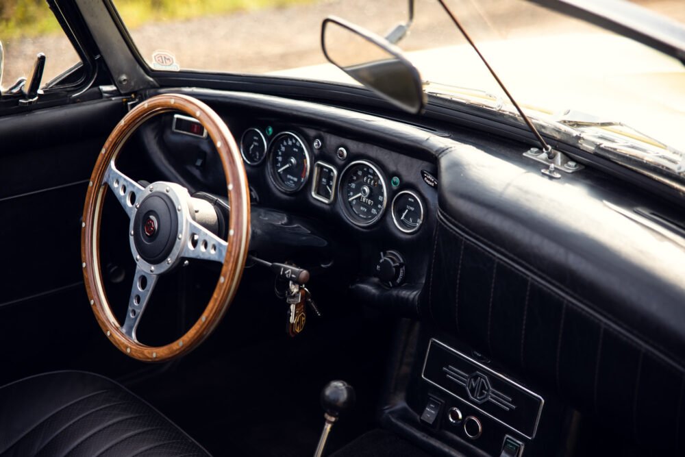 Vintage car interior with wooden steering wheel.