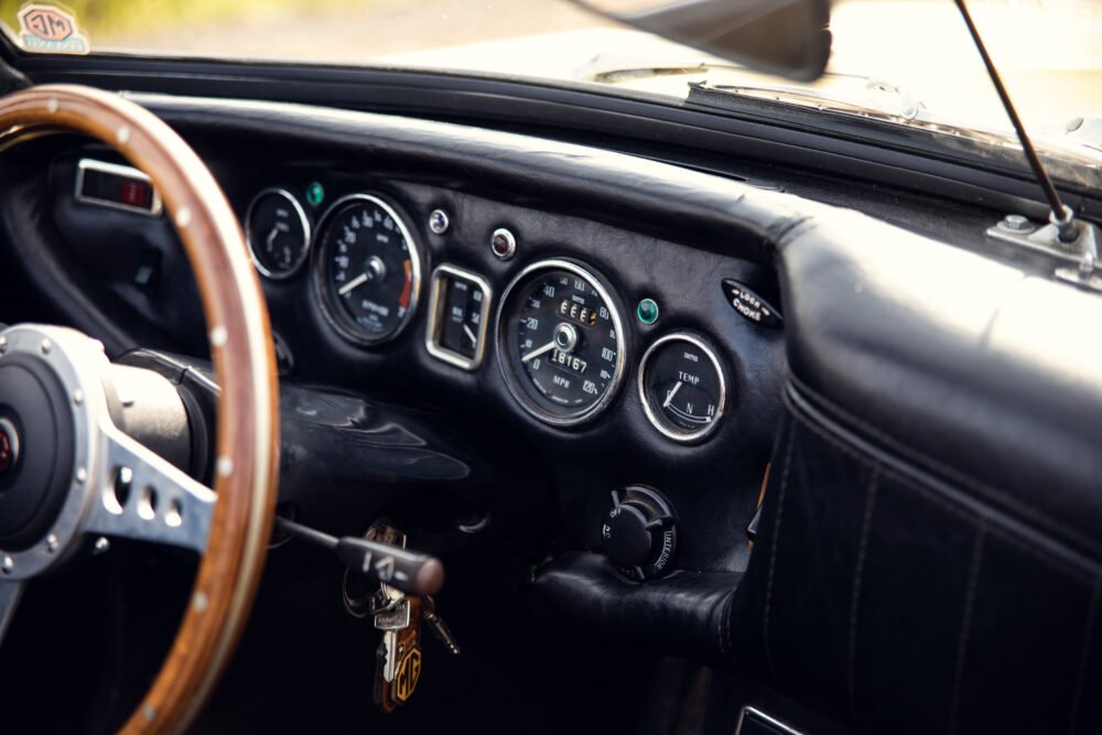 Vintage car dashboard with wooden steering wheel.