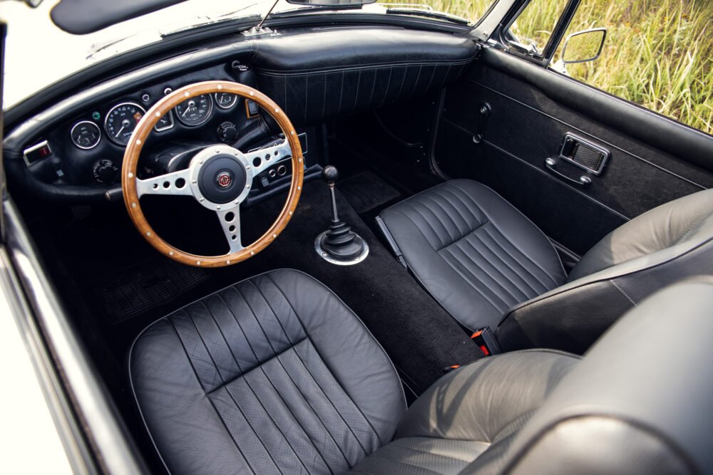 Vintage MG car interior with wooden steering wheel.