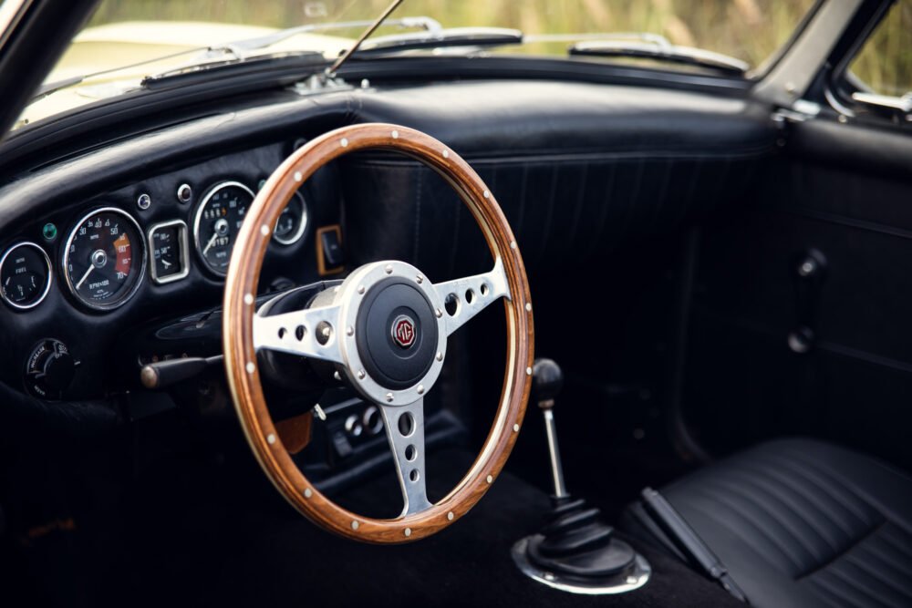 Vintage MG car's dashboard and wooden steering wheel.