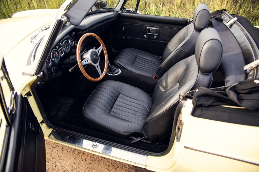 Vintage convertible car interior with wooden steering wheel.