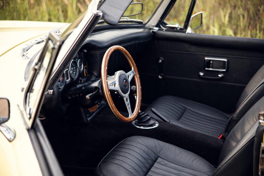 Vintage car interior with wooden steering wheel.