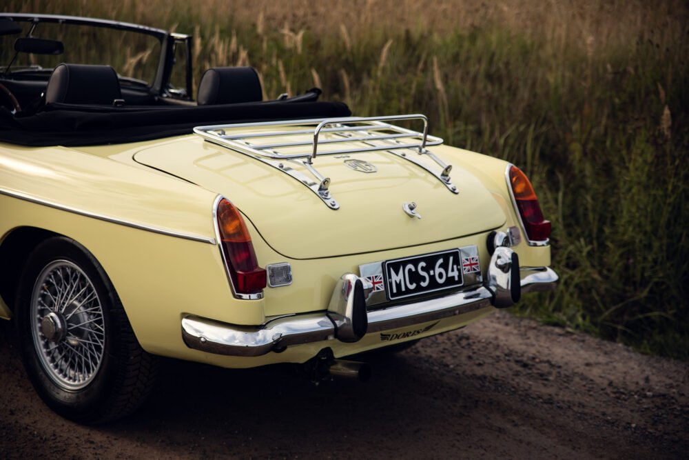 Vintage yellow convertible car in a natural setting.