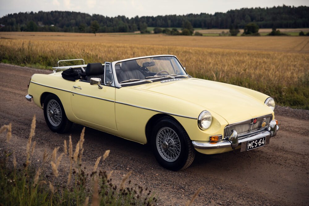 Vintage yellow convertible car on country road.