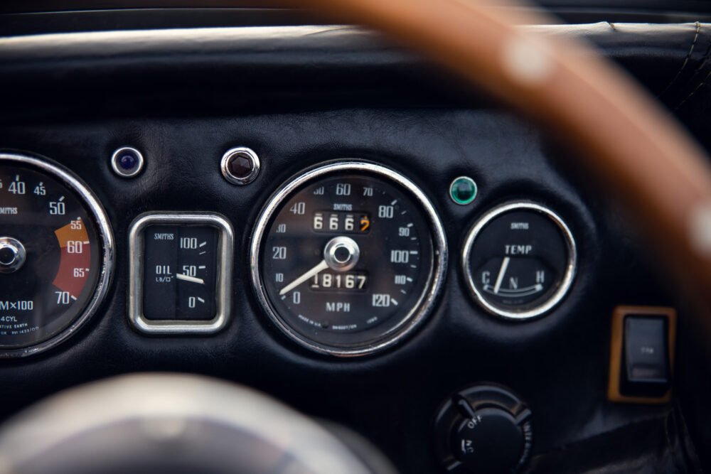 Vintage car dashboard with speedometer and gauges.