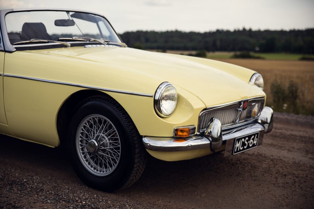 Vintage yellow convertible car on country road.