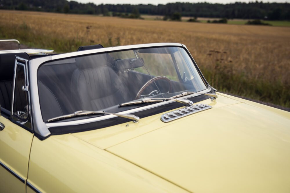 Yellow vintage convertible car in golden wheat field