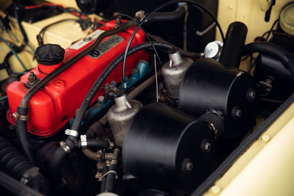 Vintage car engine close-up, red cover and components.