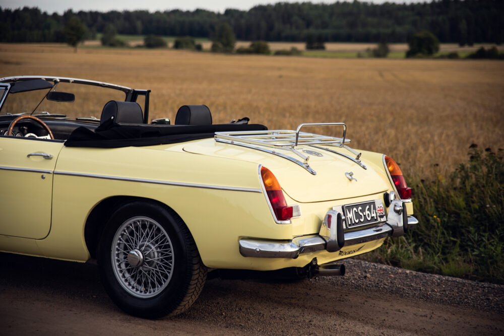 Yellow vintage convertible car in rural setting.