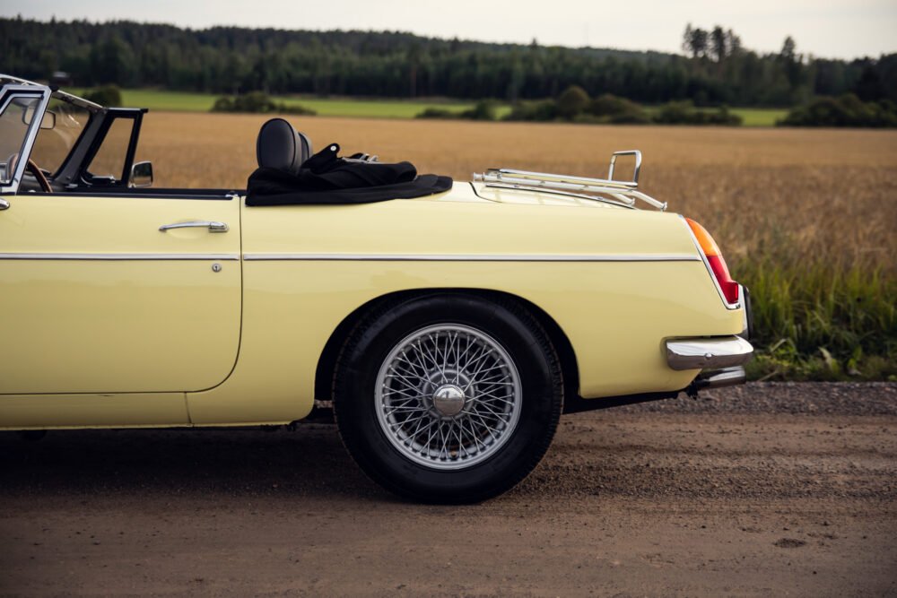 Yellow vintage convertible car near a field.