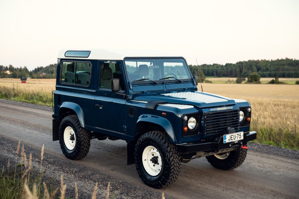 Blue Land Rover Defender parked on rural road