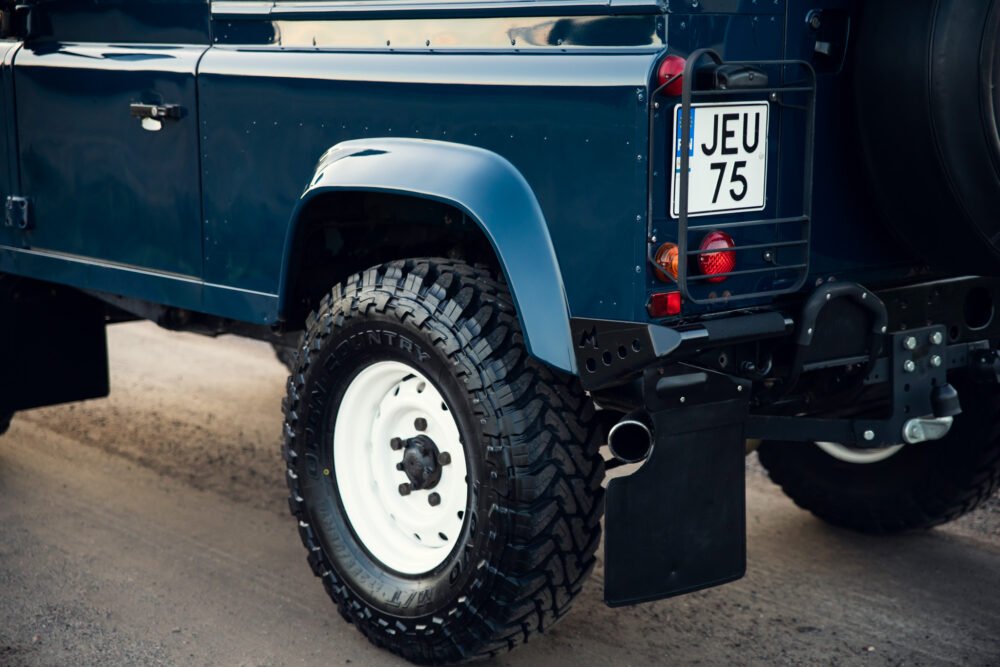 Blue off-road vehicle rear view with license plate JEU 75.