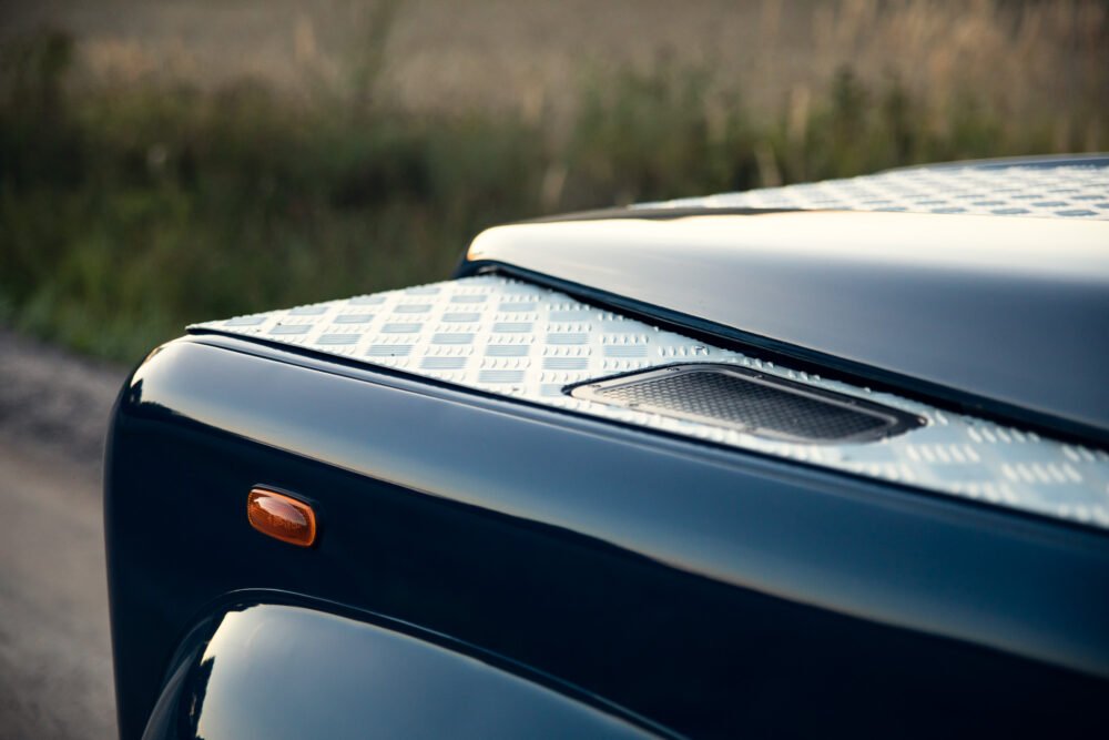 Close-up of blue sports car's rear with ventilation grille.