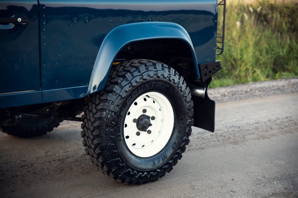 Blue off-road vehicle's rugged tire and fender.