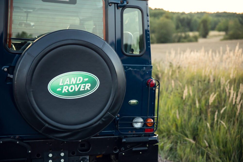 Land Rover spare tire cover on vehicle in nature.