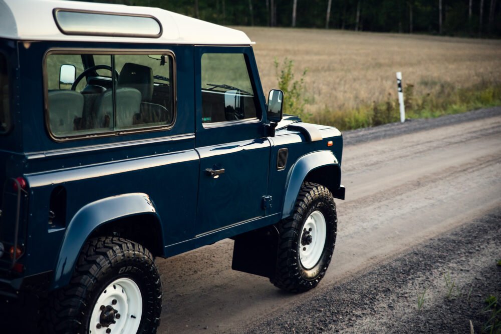 Blue off-road vehicle parked on dirt road.