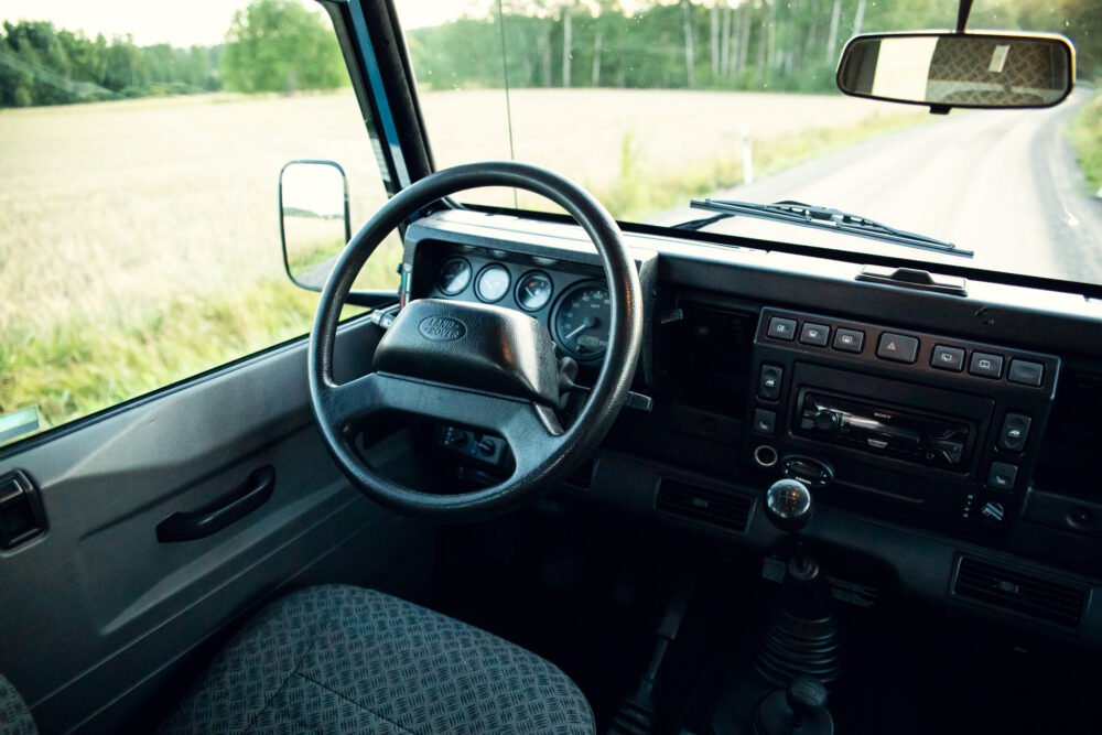 Interior of Land Rover driving on rural road.