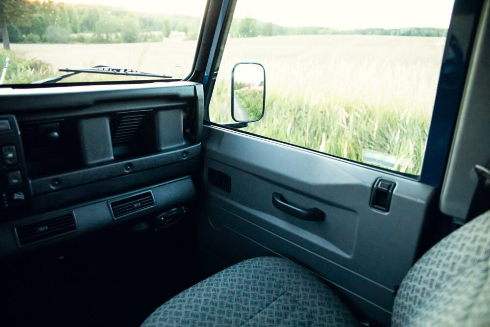 Interior view of a vintage car overlooking a field.