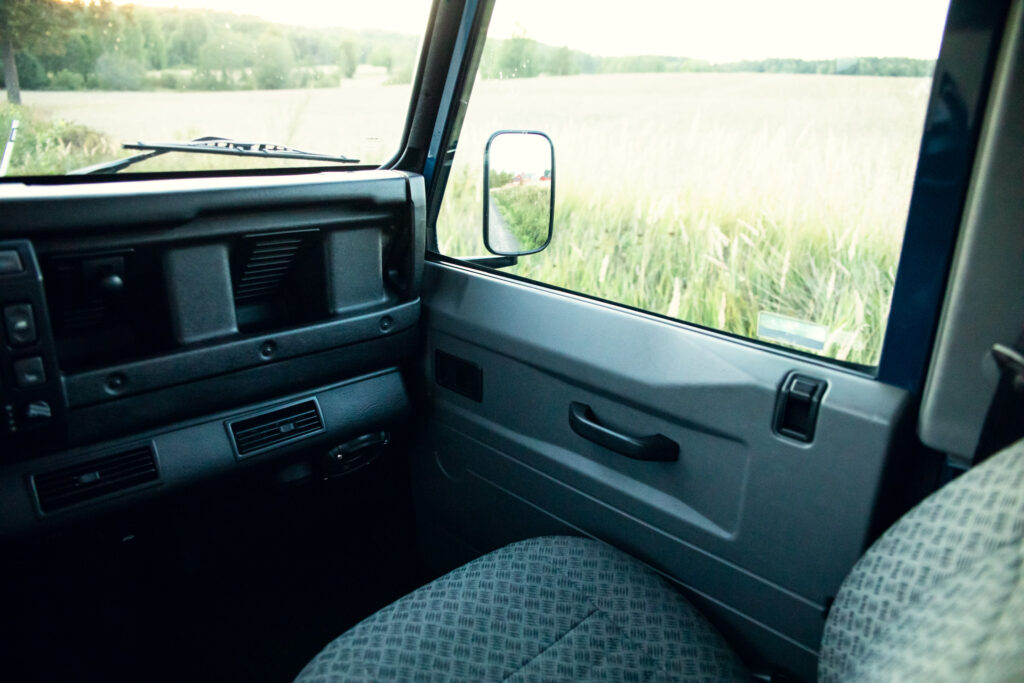 Interior view of a vintage car overlooking a field.