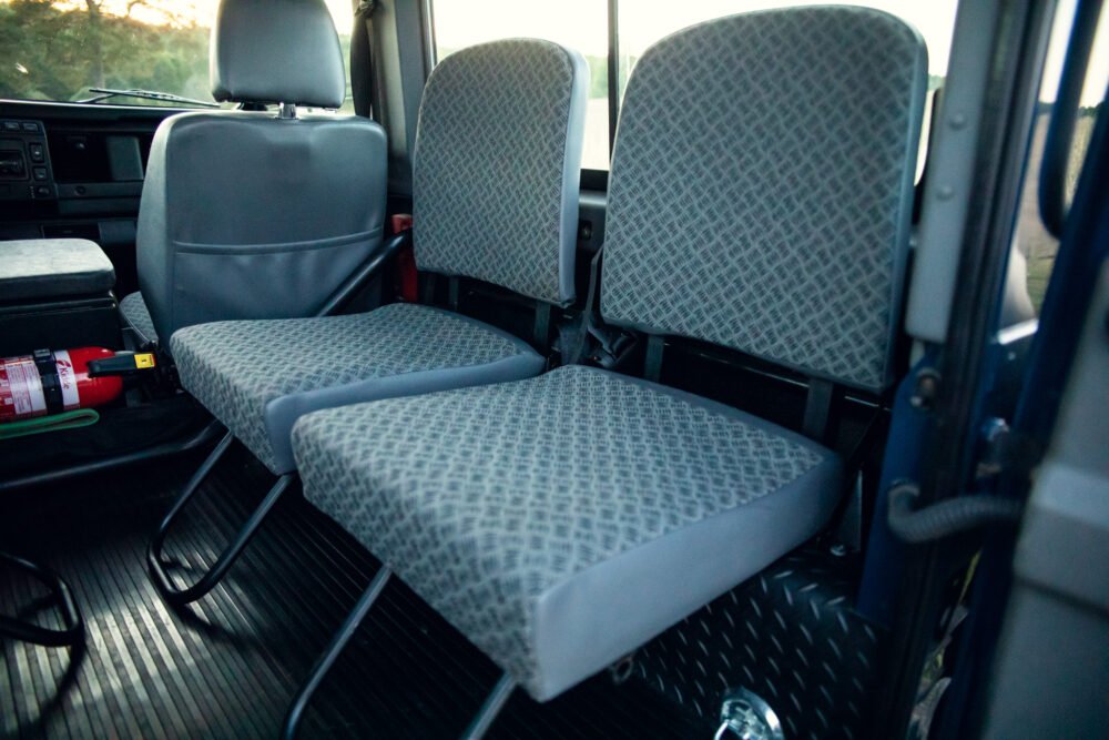 Interior view of empty bus seats and dashboard.