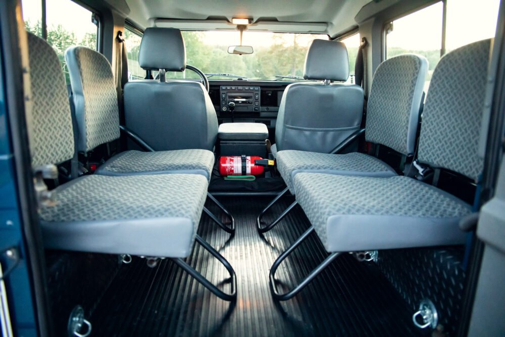 Interior view of empty van with rows of seats.