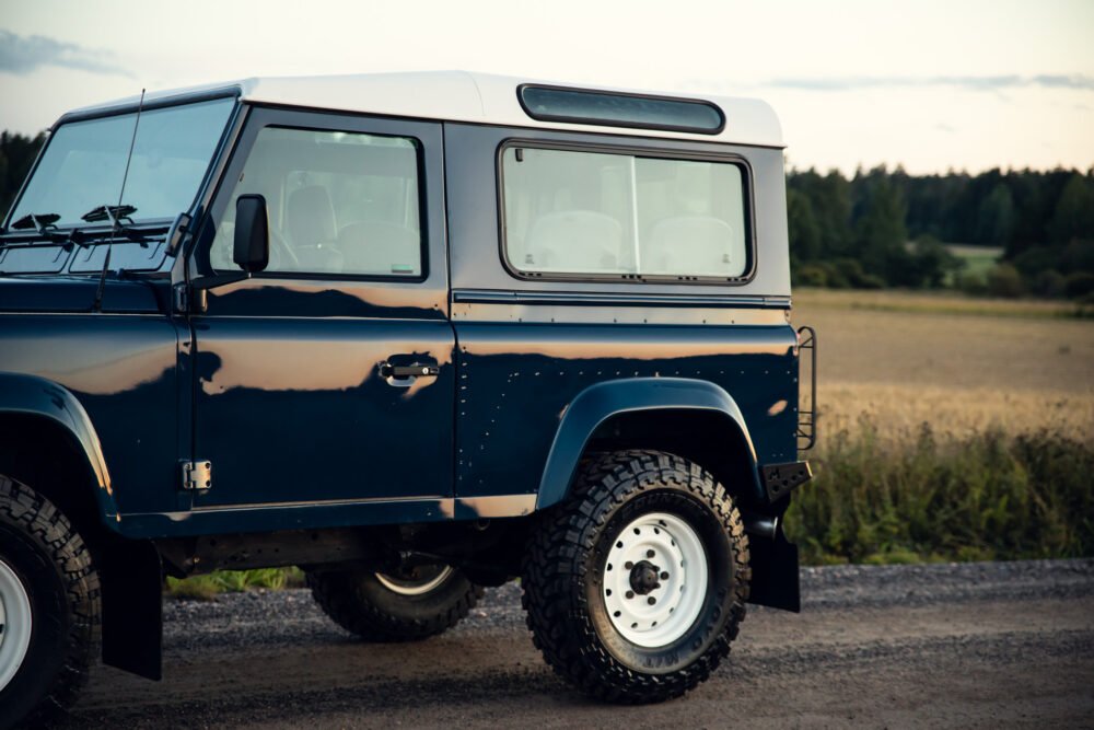 Blue off-road vehicle parked on rural road.