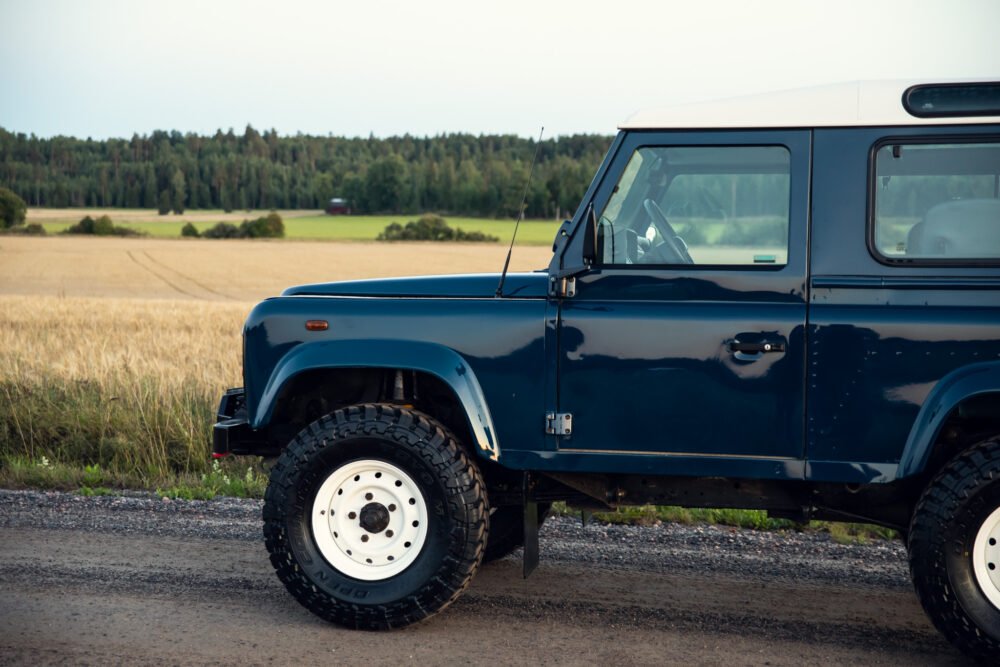 Blue off-road vehicle parked near wheat field.