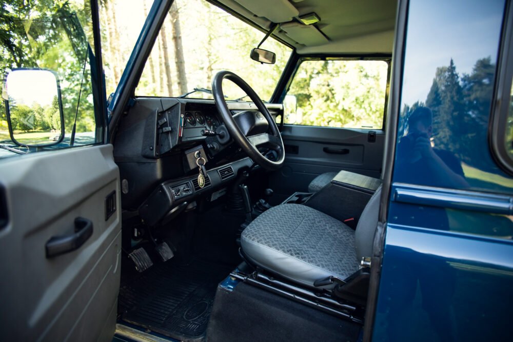 Interior view of vintage vehicle with open driver's door.