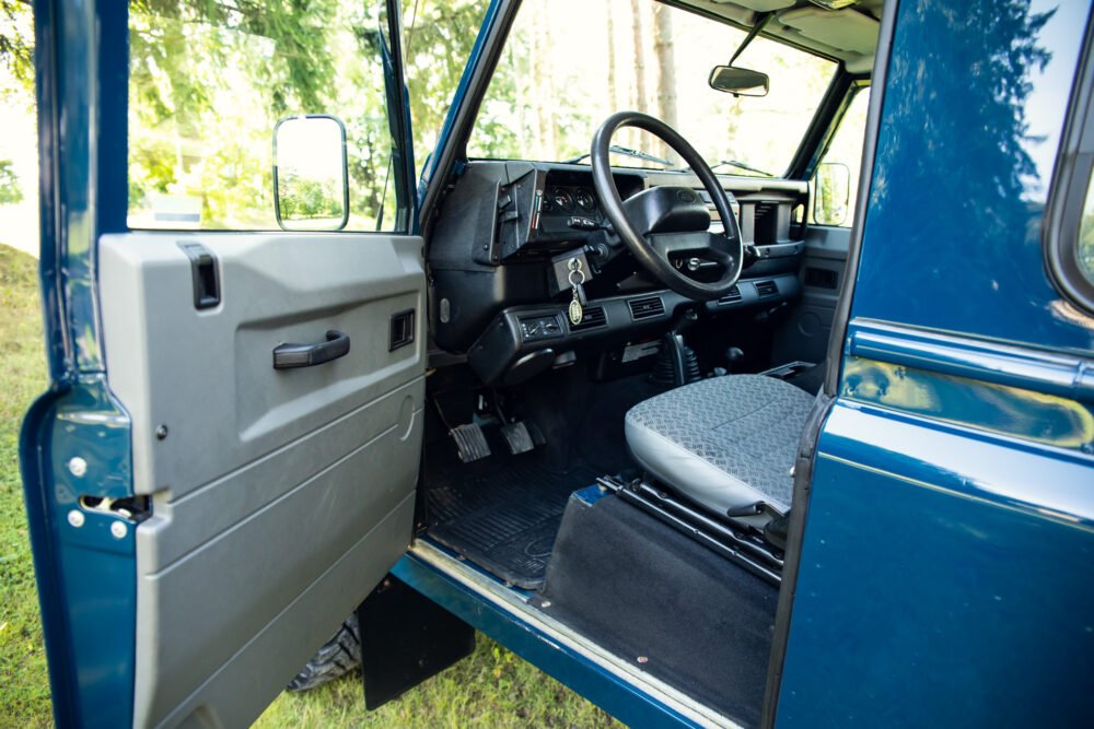 Interior view of vintage blue SUV with open door.