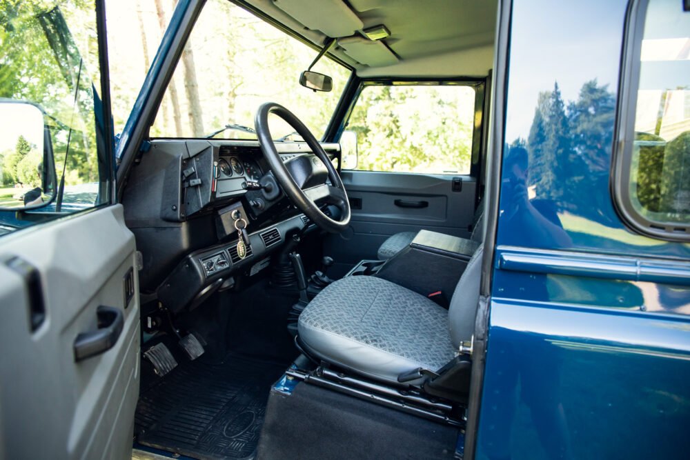 Interior view of a vintage blue vehicle's driver seat.