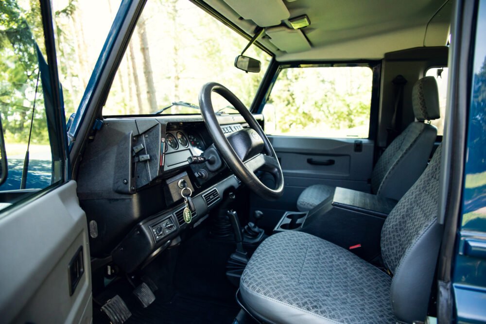 Interior of vintage vehicle with patterned seats and dashboard.