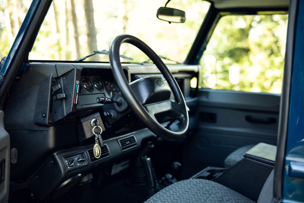 Vintage vehicle interior with steering wheel and dashboard.