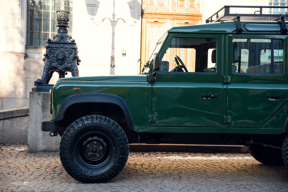 Green SUV parked near ornate street lamp.