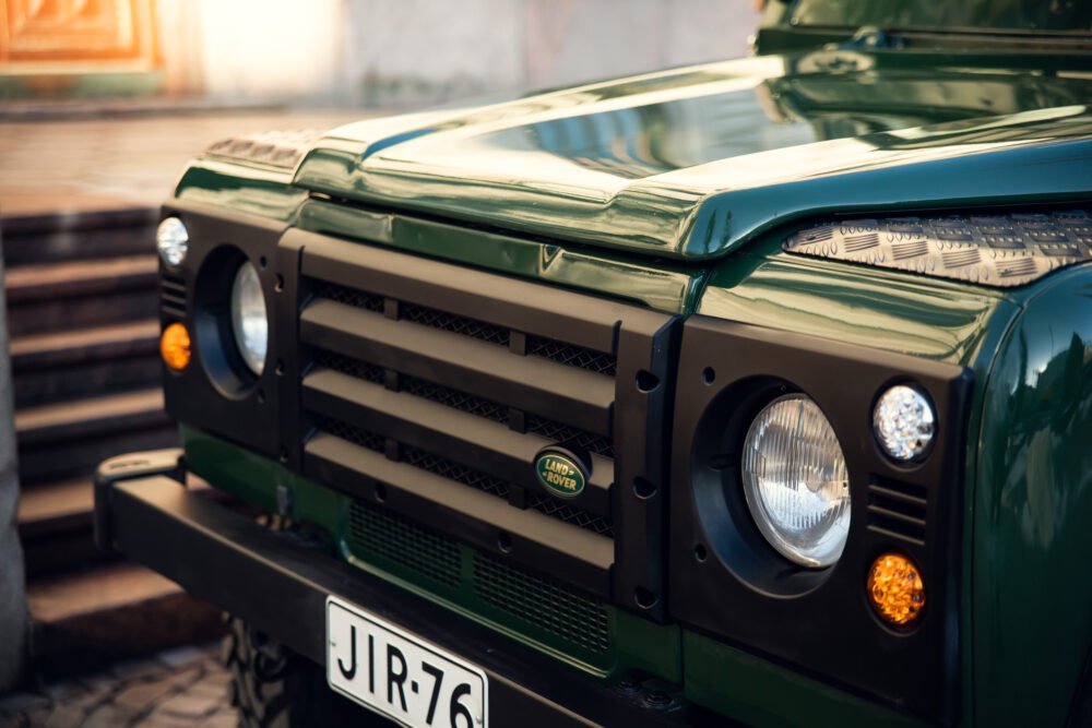 Green Land Rover front grille and headlights close-up.