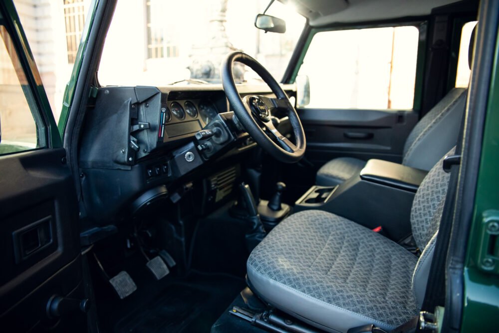 Interior of a vintage green SUV with patterned seats.