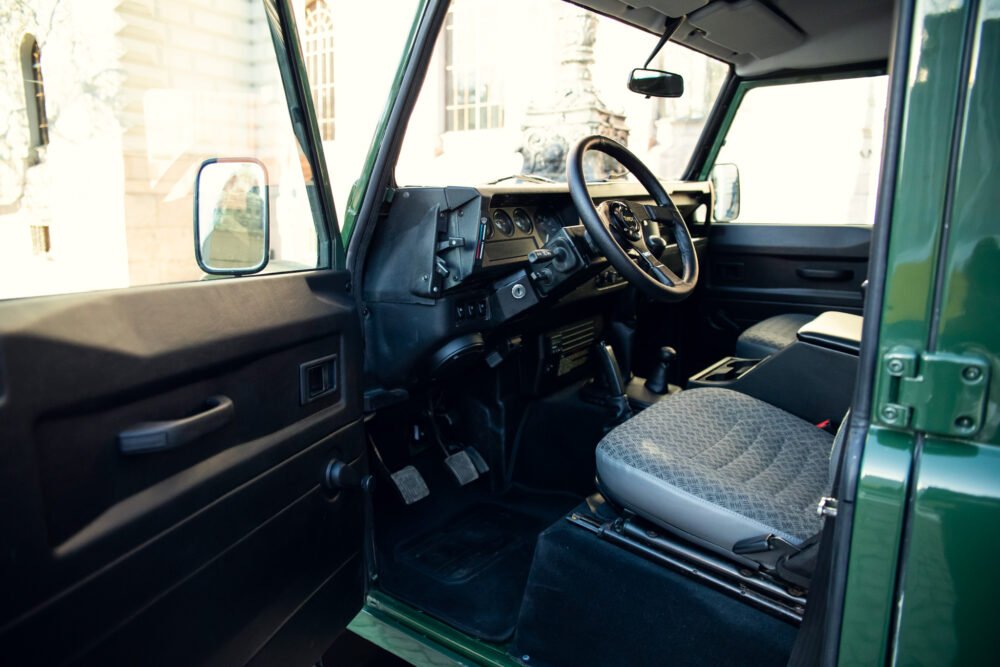 Vintage car's interior with steering wheel and dashboard.