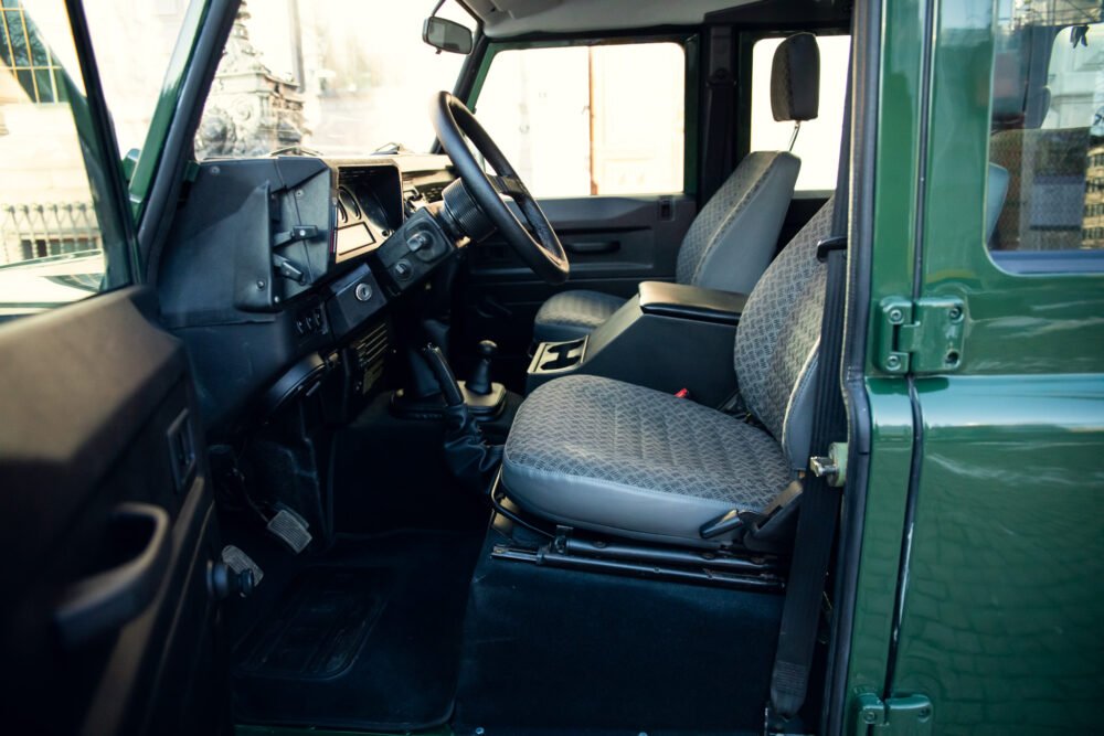 Interior of green SUV with patterned seats and dashboard.