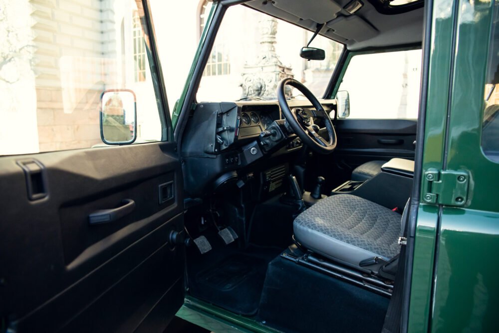 Vintage green SUV interior, steering wheel and dashboard visible.