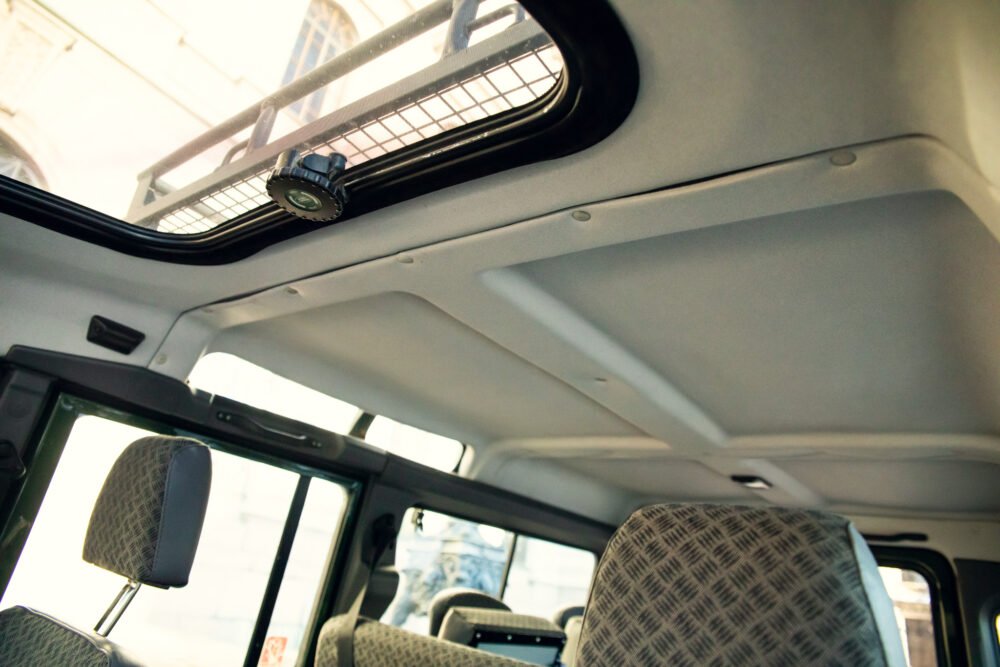 Van interior with sunlight through open sunroof.