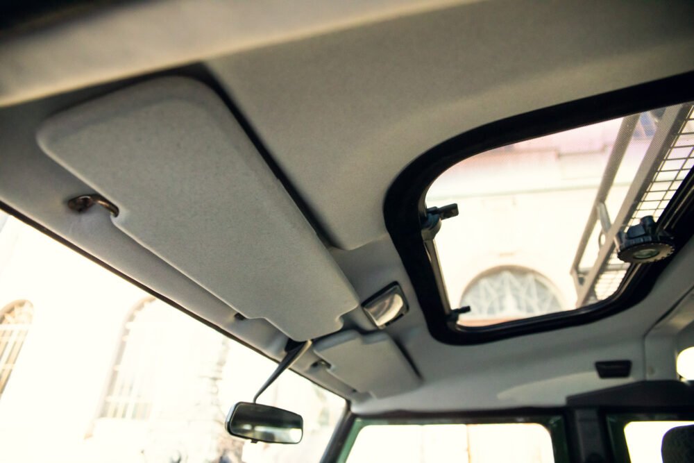 Car interior showing sun visors and rearview mirror.