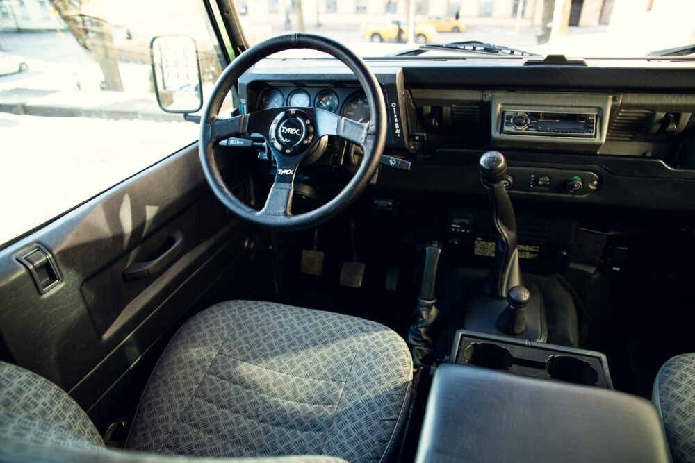 Vintage car interior with steering wheel and dashboard.